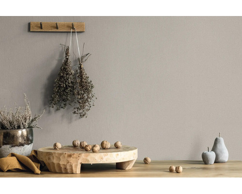 Muurverf in taupe kleur in een rustieke woonomgeving met houten plank, walnoten en gedroogde kruiden.