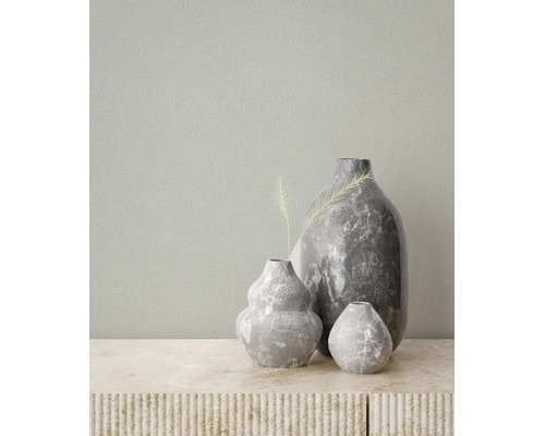 Gestructureerd behang met fijne verticale lijnen in een kamer met decoratieve vazen met marmerlook op een stenen oppervlak.