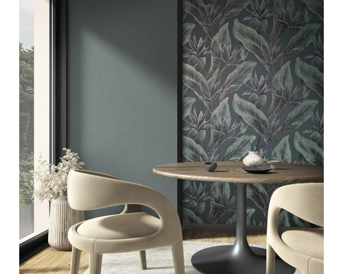 Vliesfotobehang met jungle-motief en tropische bladeren in een moderne eethoek met houten tafel en gebogen stoelen.