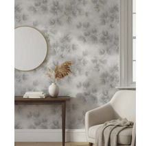 Vliesbehang met gestructureerd bloemenpatroon in een lichte woonkamer met spiegel en fauteuil.