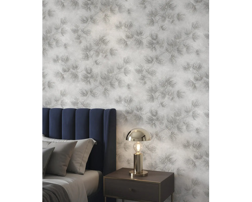 Gestructureerd behang met een floraal naaldpatroon in een slaapkamer met een gestoffeerd hoofdbord, kussens en een metalen nachtlampje.