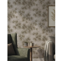 Gestructureerd vliesbehang met een op de natuur geïnspireerd bladerpatroon in een sfeervolle woonkamer met fauteuil en bijzettafel.