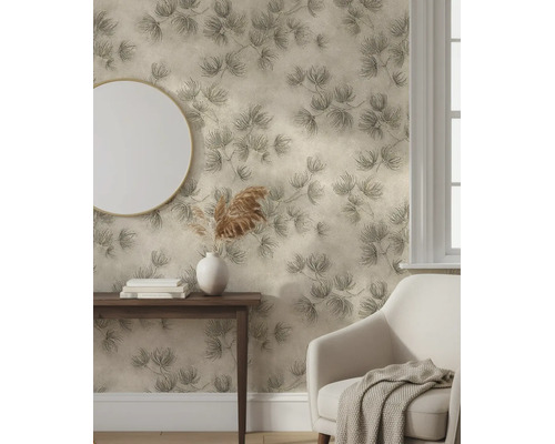 Vliesbehang met botanisch patroon van dennentakken in een lichte kamer met fauteuil, tafel en spiegel.