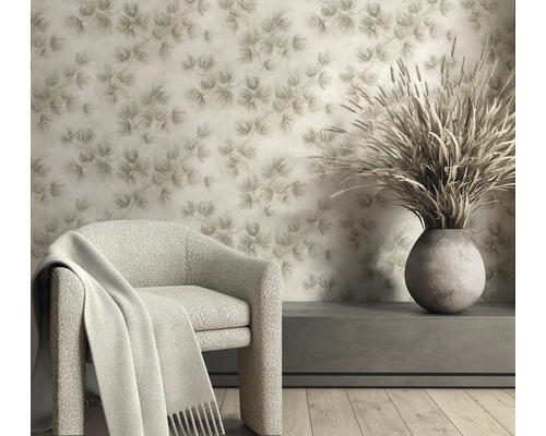 Vliesbehang met dennennaaldenpatroon in een lichte woonkamer met fauteuil en vaas met droogbloemen.