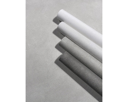 Vier gestructureerde behangrollen in verschillende grijstinten met een steenlook oppervlak.