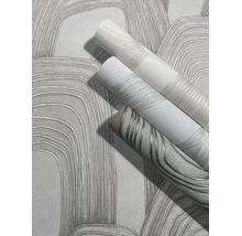 Detailopname van vliesbehang met een abstract, gebogen lijnenpatroon en voelbare textuur.