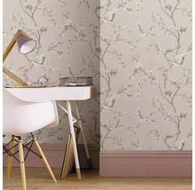 Behang met bloemen- en vogelpatroon in een lichte werkkamer met een wit bureau en een witte stoel.