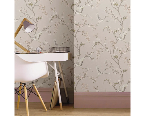 Behang met bloemen- en vogelpatroon in een lichte werkkamer met een wit bureau en een witte stoel.
