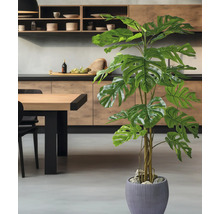 Kunstmatige Monstera plant in een antracietkleurige pot, staand in een moderne keuken met houten elementen en een grijze vloer.