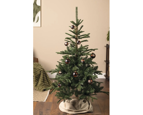 Kunstkerstboom versierd met bruine kerstballen met stervormig motief in een woonkamer.