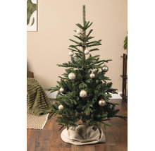 Kerstboom gedecoreerd met champagnekleurige kerstballen met sneeuwvlokkenpatroon in een woonkamer.