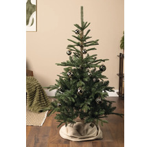 Gedecoreerde kunstkerstboom met donkere kerstballen met ruitpatroon in een woonkamer met houten vloer.