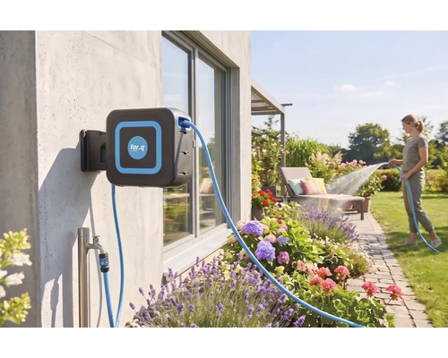 Wandslangenbox met for.q Logo aan een huismuur in een lichte tuin, een vrouw besproeit bloembedden met de tuinslang.