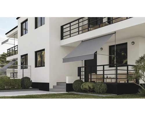Grijs klemscherm op een terras van een modern wit huis met zwarte leuningen en tuin.