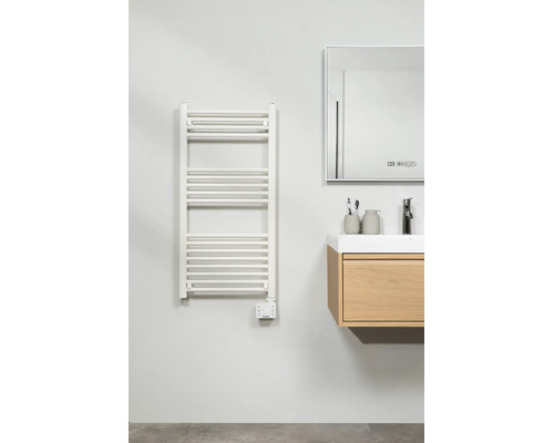 Lichte, moderne badkamer met een elektrische handdoekradiator, een houten wastafelmeubel met wasbak en een spiegel.