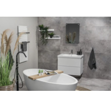 Moderne badkamer met vrijstaand bad, wit badmeubel en grijze tegels met betonlook.