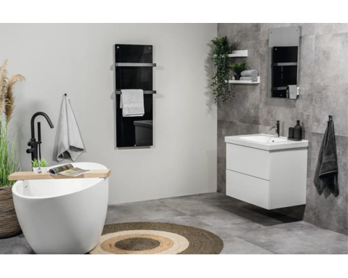 Moderne badkamer met vrijstaand ligbad, wit wastafelmeubel, zwarte radiator en grijze vloertegels.