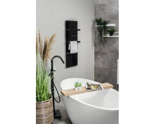 Moderne badkamer met vrijstaand bad, zwarte vrijstaande kraan en een verticale glazen badkamerradiator met handdoekrek.