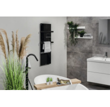 Moderne badkamer met zwarte glazen handdoekradiator, vrijstaand bad en wit wastafelmeubel tegen een grijze wand met steenlook.