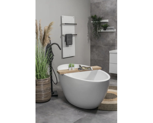 Lichte, moderne badkamer met vrijstaand wit bad, zwarte staande kraan, handdoekradiator en decoratieve houten elementen.