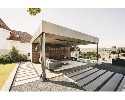 Moderne, lichte pergola van metaal met houten lamellenwand, gordijnen en loungeset op een houten terras in de tuin.