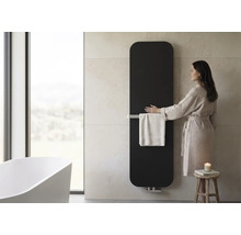 Verticale badkamerradiator met handdoekhouder in een moderne badkamer met vrijstaand bad en vrouw in badjas.