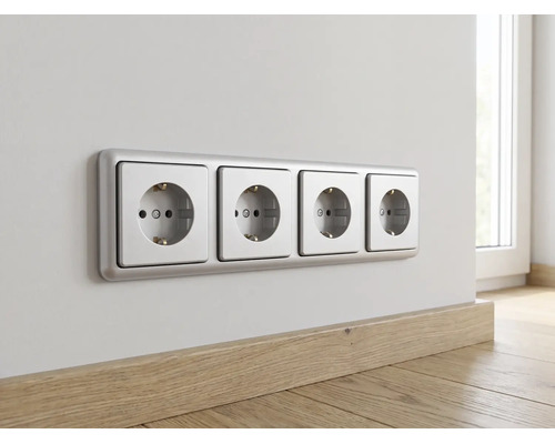 Horizontale 4-voudige wandcontactdoos met randaarde en zilverkleurig frame op een muur boven een houten plint in een lichte kamer.