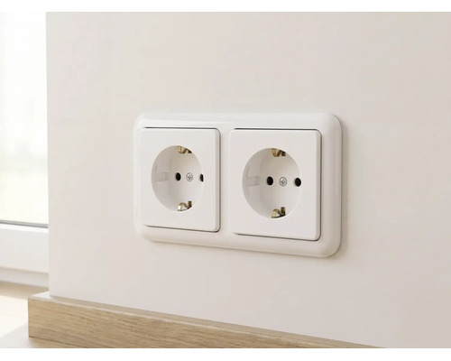 Dubbele wandcontactdoos met randaarde horizontaal gemonteerd op een muur boven een plint.