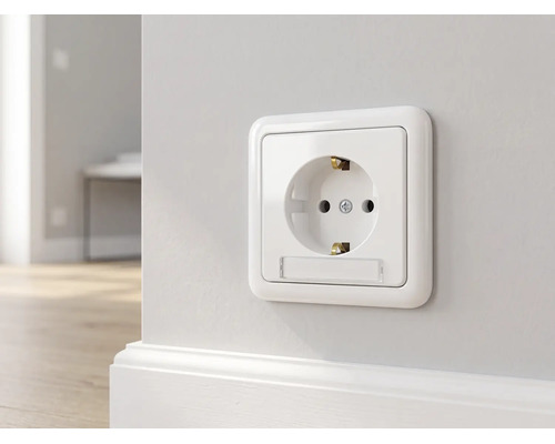Schuko stopcontact met tekstveld gemonteerd op een wand boven een plint.