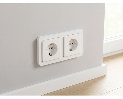 Dubbele wandcontactdoos met randaarde gemonteerd op een muur boven een witte plint.