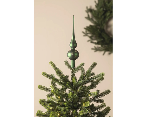Kerstboompiek met sterrenpatroon op een kunstkerstboom met verlichting.