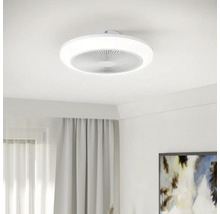 Moderne ronde plafondventilator met geïntegreerde LED-lichtring, gemonteerd aan een wit plafond in een lichte kamer.