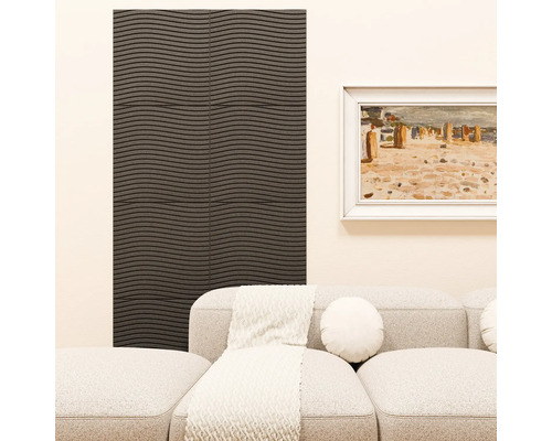 Woonkamer met donker wandpaneel met horizontaal golfpatroon. Daarnaast een lichte bank met sierkussen, deken en een ingelijst schilderij aan de wand.