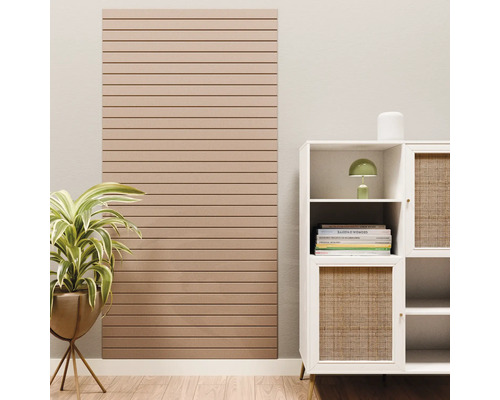 Akoestisch paneel met horizontale lamellen aan een wand naast een kast en een kamerplant.