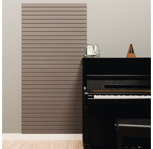 Akoestisch paneel met horizontale latten aan een muur naast een zwarte piano in een lichte kamer.