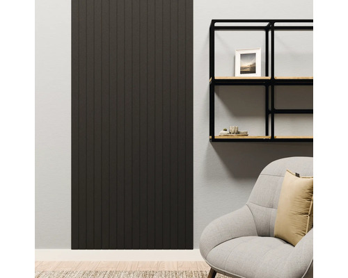 Donker wandpaneel met verticale lamellen in een modern ingerichte woonkamer naast een zwart wandrek en een fauteuil.