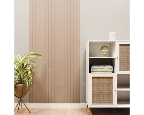 Wandpaneel met verticale lamellen in een lichte woonkamer naast een wit dressoir en een kamerplant.