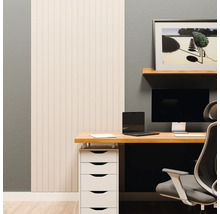 Moderne werkplek met lichte wandpanelen, een houten bureau, monitor, laptop en een wit ladekastje voor een grijze muur.