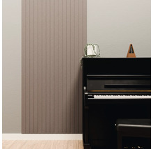 Moderne wandpanelen met verticale lamellen naast een zwarte piano in een lichte kamer met een lichte houten vloer.