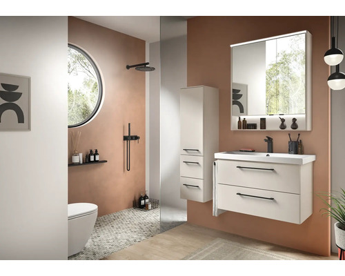 Moderne badkamerset met wit wastafelmeubel, spiegelkast met verlichting, hoge kast en zwarte kranen.
