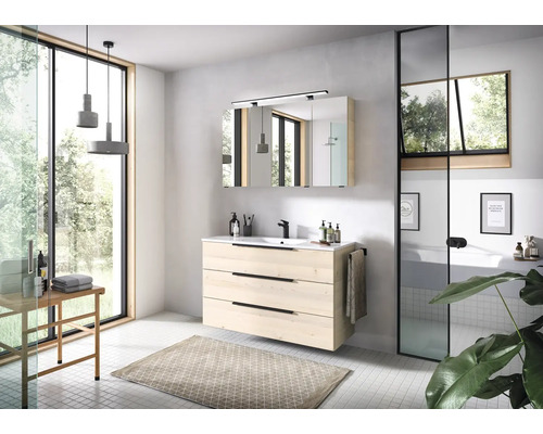 Moderne badkamer met wastafelmeubel in lichte houtlook, zwarte kraan, spiegelkast en groot raam voor een lichte, ruime sfeer.