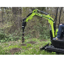 Zipper minigraafmachine met grondboor-hulpstuk bij het graven van gaten in een lichte tuin.