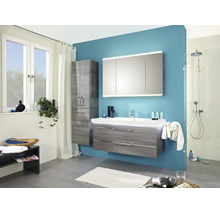 Moderne badkamer met grijs wastafelmeubel, driedeurs spiegelkast met verlichting, kolomkast en inloopdouche tegen een blauwe wand.