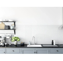 Moderne, lichte keuken met een achterwand met geometrisch patroon, witte inbouwspoelbak, chromen kraan en grijze onderkasten.