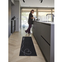 Zwarte keukenloper met tekst Kitchen en hart op lichte houten vloer in een moderne, lichte keuken.