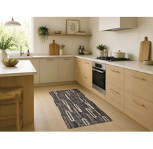Moderne keukenloper met een abstract ovaal patroon in een lichte keuken met houten kasten en witte werkbladen.