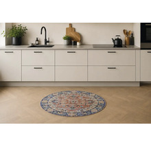 Rond keukentapijt met oosters patroon in een lichte, moderne keuken met houten vloer.