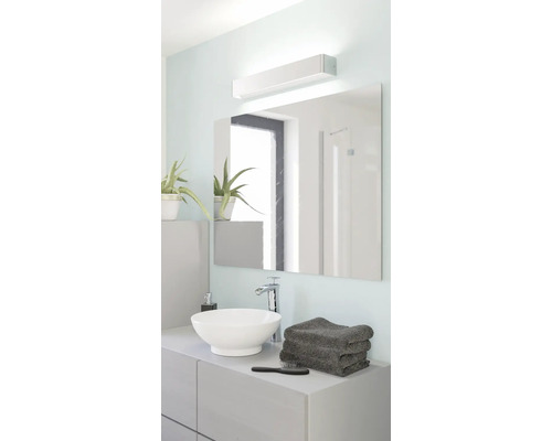 Moderne, lichte badkamer met witte opzetwastafel, chromen kraan, grote rechthoekige spiegel en led-spiegelarmatuur.