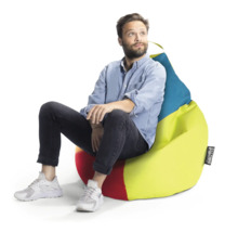 Een man zit op een kleurrijke zitzak met handgreep en Sitting Point Logo.