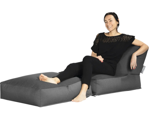 Tweedelige zitzak loungeset bestaande uit een fauteuil met rugleuning en bijpassende hocker, waarop een vrouw zit.